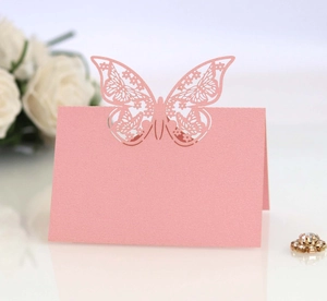 Detail of pink laser-cut butterfly table card on pearlescent paper for wedding decor