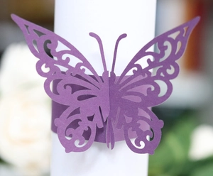 Macro shot of purple laser-cut butterfly napkin ring with delicate hollow scroll patterns