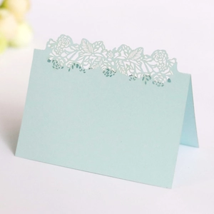 Detail of light blue laser-cut rose hollow place card for wedding table setting
