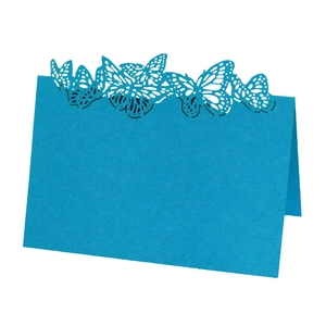 Detail showing blue laser-cut butterfly hollow pattern on paper wedding place cards