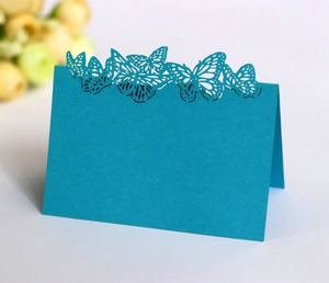 Detailed close-up of dark blue laser-cut butterfly place card for wedding table decoration