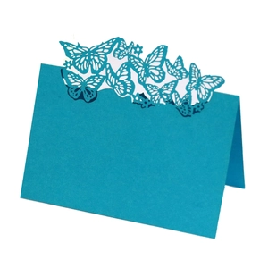 Macro shot of laser-cut blue butterfly place card with intricate hollow pattern details