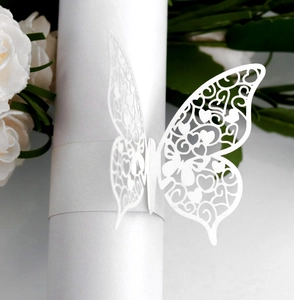 Macro shot of white laser-cut butterfly napkin ring with intricate hollow heart patterns