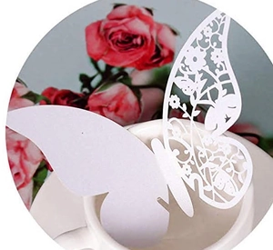 Laser-cut white butterfly wine glass card with intricate hollow floral patterns on a ceramic cup