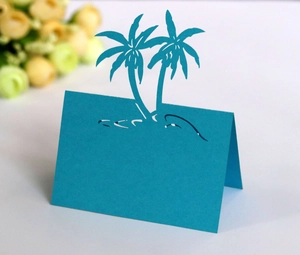 Close-up of laser-cut palm tree place cards in deep blue for beach weddings