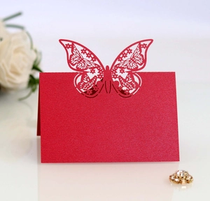 Close-up of red butterfly laser-cut place card with elegant pearlescent finish and floral decor