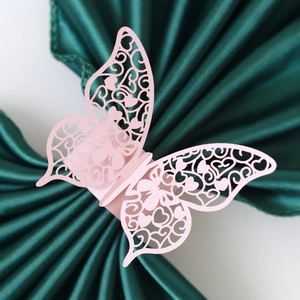 Laser cut pink butterfly napkin rings with intricate heart patterns for wedding decor