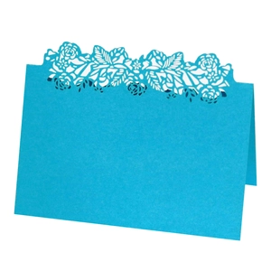 Detail of sky blue laser-cut floral wedding place card with intricate lace patterns