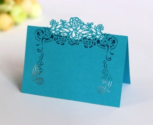 Detail view of blue laser-cut rose hollow place card for wedding and banquet table decor