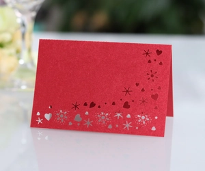 Detailed laser-cut heart pattern on a red pearlescent card for wedding table settings