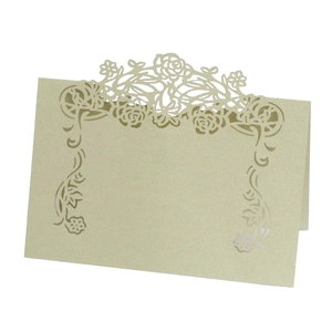 Detail of laser-cut rose patterns on elegant beige pearlescent paper table name cards