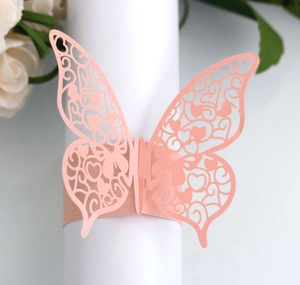 Detail view of pink butterfly napkin ring with laser-cut hollow patterns for wedding decor