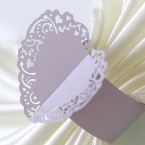 Close-up of lavender laser-cut paper napkin ring with floral and heart hollow patterns
