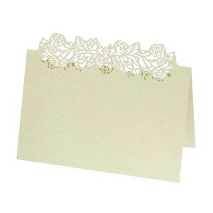 Detail of laser-cut rose floral hollow design on pale green wedding place card