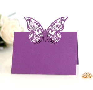 Detail of laser-cut butterfly place card in purple pearlescent paper for wedding decor