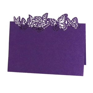 Macro shot of purple laser-cut place card featuring intricate butterfly hollow pattern
