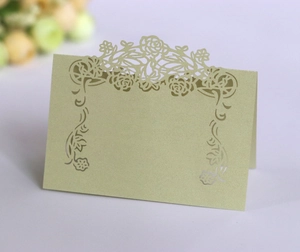 Detailed laser-cut rose pattern on champagne pearlescent paper table seating card