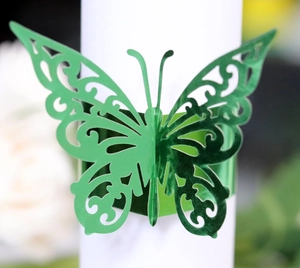 Close-up of laser-cut butterfly napkin ring with metallic green hollowed detail