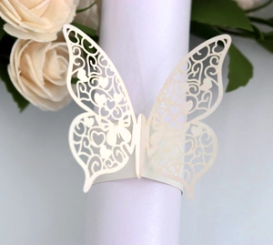 Detail of laser-cut butterfly napkin ring in pearl white with floral hollow patterns