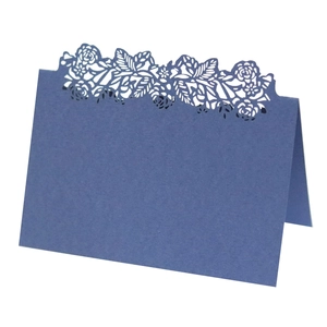 Detail showing deep blue laser-cut floral pattern on a formal wedding seat card