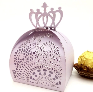 Macro detail of laser-cut purple gift box with crown handle and gold chocolate