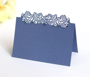 Detailed laser-cut navy blue wedding place card with intricate floral镂空 patterns