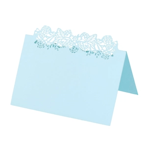 Detail of light blue laser-cut floral place card standing on a clean white background