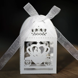 Detail view of laser-cut white favor box with crown carriage and elegant organza ribbon