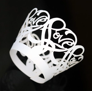 White pearlescent paper cupcake wrapper with laser-cut love heart and crown design