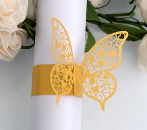 Macro detail of laser-cut butterfly napkin ring with hollow heart patterns for weddings