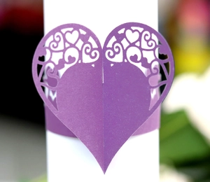 Detail of purple laser-cut heart napkin ring with intricate scroll patterns and texture