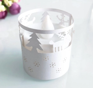 Filigrane ausgeschnittene Weihnachtsmuster auf einem LED-Kerzenhalter aus weißem Papier