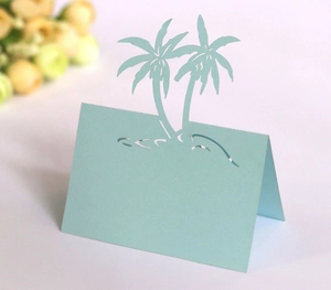 Detail of laser-cut palm tree place cards in light blue for wedding or beach party