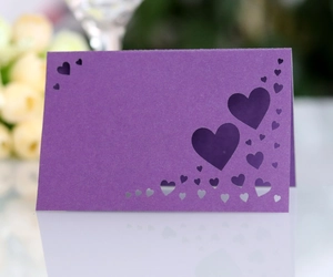 Detailed close-up of purple laser-cut heart seat card with elegant hollowed pattern