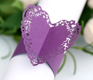 Detail of laser-cut heart napkin ring in deep purple with intricate floral hollow patterns