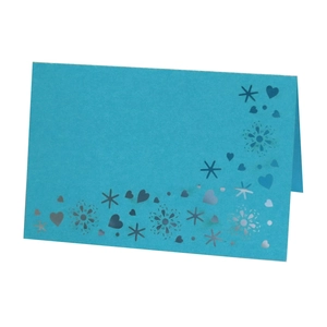 Detail view of blue folded place card with silver heart and snowflake foil accents