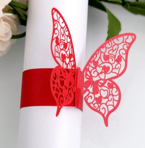 Detailed close-up of red laser-cut butterfly napkin ring with intricate heart patterns