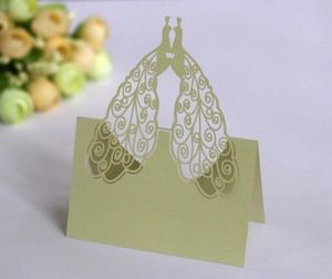 Macro detail of laser-cut peacock place card in light green for wedding table decor