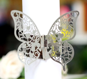 Macro shot of silver laser-cut butterfly napkin ring with hollow floral patterns