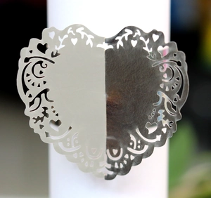 Macro detail of laser-cut lavender heart napkin ring with intricate floral lace pattern