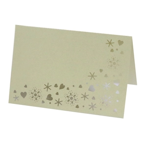 Close-up of light green laser cut wedding place card with silver foil snowflakes and heart