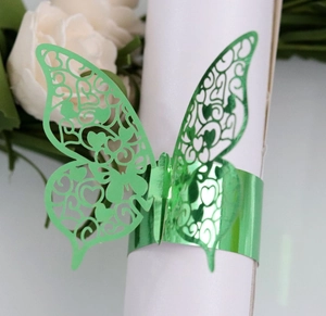 Detailed macro of laser-cut green metallic butterfly napkin ring with hollow patterns