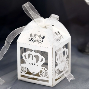 Detail of white laser-cut pumpkin carriage gift box with crown top and silk ribbon bow