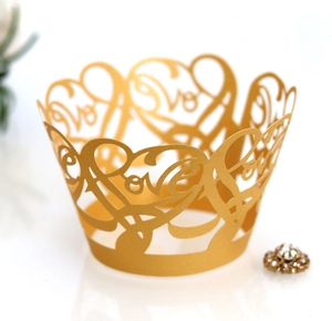 Detail of laser-cut Love design on golden pearlescent paper cupcake wrappers