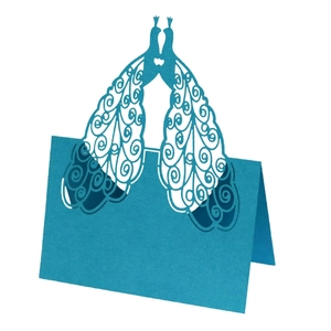Elegant blue laser-cut peacock place card with intricate hollow design for wedding table