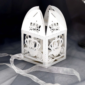 Detail of white laser-cut hollow paper gift box featuring pumpkin carriage and crown patterns