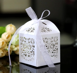 Macro view of white laser-cut hollow gift box with floral patterns and a ribbon bow