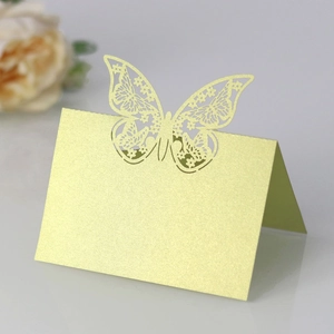 Macro detail of laser-cut butterfly place card in pearlized pale gold paper