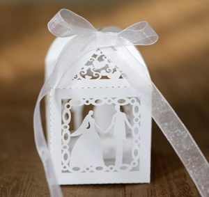 Detailed laser cut white wedding favor box with bride and groom silhouette and ribbon