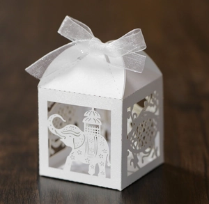 White laser-cut elephant candy box made of pearlescent paper with an elegant ribbon bow